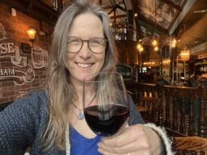 Woman holding up a glass of red wine.