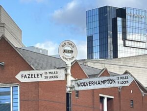 Canal signs indicating Fazely to the left (15 miles and 38 locks) and Wolverhampton to the right (13 miles and 3 locks)