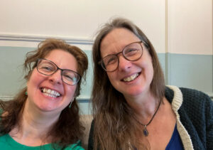 Two women with glasses, grinning into the camera.