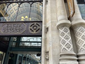 Entrance to an arcade of shops. There's a carved pillar on one side and the entrance has the inscription, "Great Western Arcade".