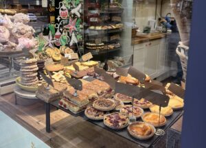 Cakes and pies as seen through a shop window.